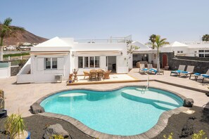 A modern villa with a swimming pool, outdoor seating, and a view of the surrounding landscape. - SAMARALDE by Buenavilla | Sea Views, Private Heated Pool in Playa Blanca (Playa Blanca)