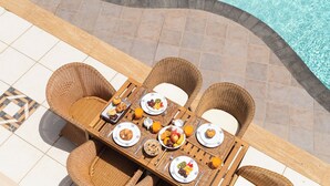 An outdoor dining area with wicker chairs and a table set for breakfast. - SAMARALDE by Buenavilla | Sea Views, Private Heated Pool in Playa Blanca (Playa Blanca)