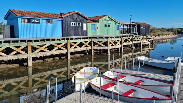 Un muelle con edificios de madera de colores y barcos amarrados.