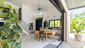 Une cuisine spacieuse avec un coin repas, un escalier et une vue sur l’extérieur.