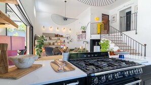 Une cuisine moderne dotée d’une grande cuisinière, de plans de travail en bois et d’un coin repas avec une table et des chaises.