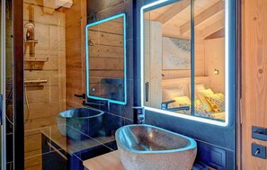 Un baño moderno con dos lavamanos, un espejo grande y detalles de madera.