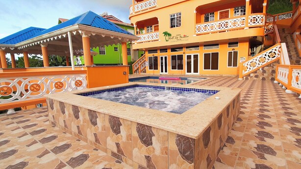 A hotel with a swimming pool, outdoor seating area, and a staircase leading to the upper floors. - Union Hilltop Paradise Villas - Premium Poolside Villa with Scenic Views (Castries)
