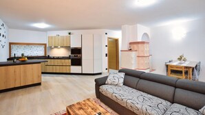 Un espace de vie compact comprenant une kitchenette, un canapé et une petite table.