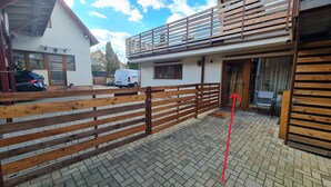 Asuinrakennus, jossa on aidattu patio, kaksikerroksinen rakennus ja näkyvissä oleva autotalli.