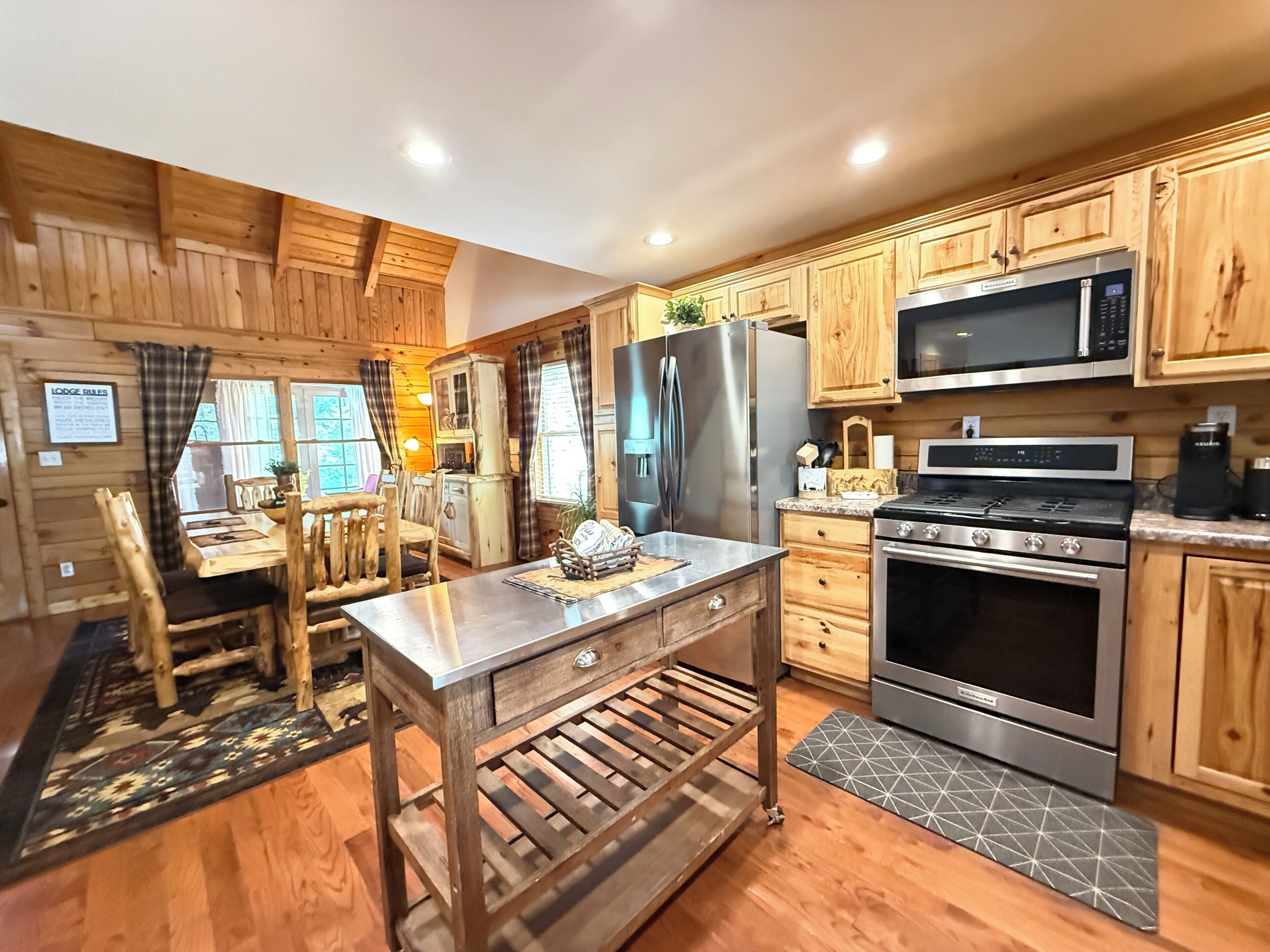 A modern kitchen with wooden cabinets, stainless steel appliances, and a central island.
