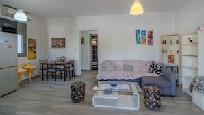 Ein modernes Wohnzimmer mit Sofa, Couchtisch und Essbereich.
