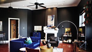 A modern living room with a blue sofa, a black armchair, and a round coffee table.