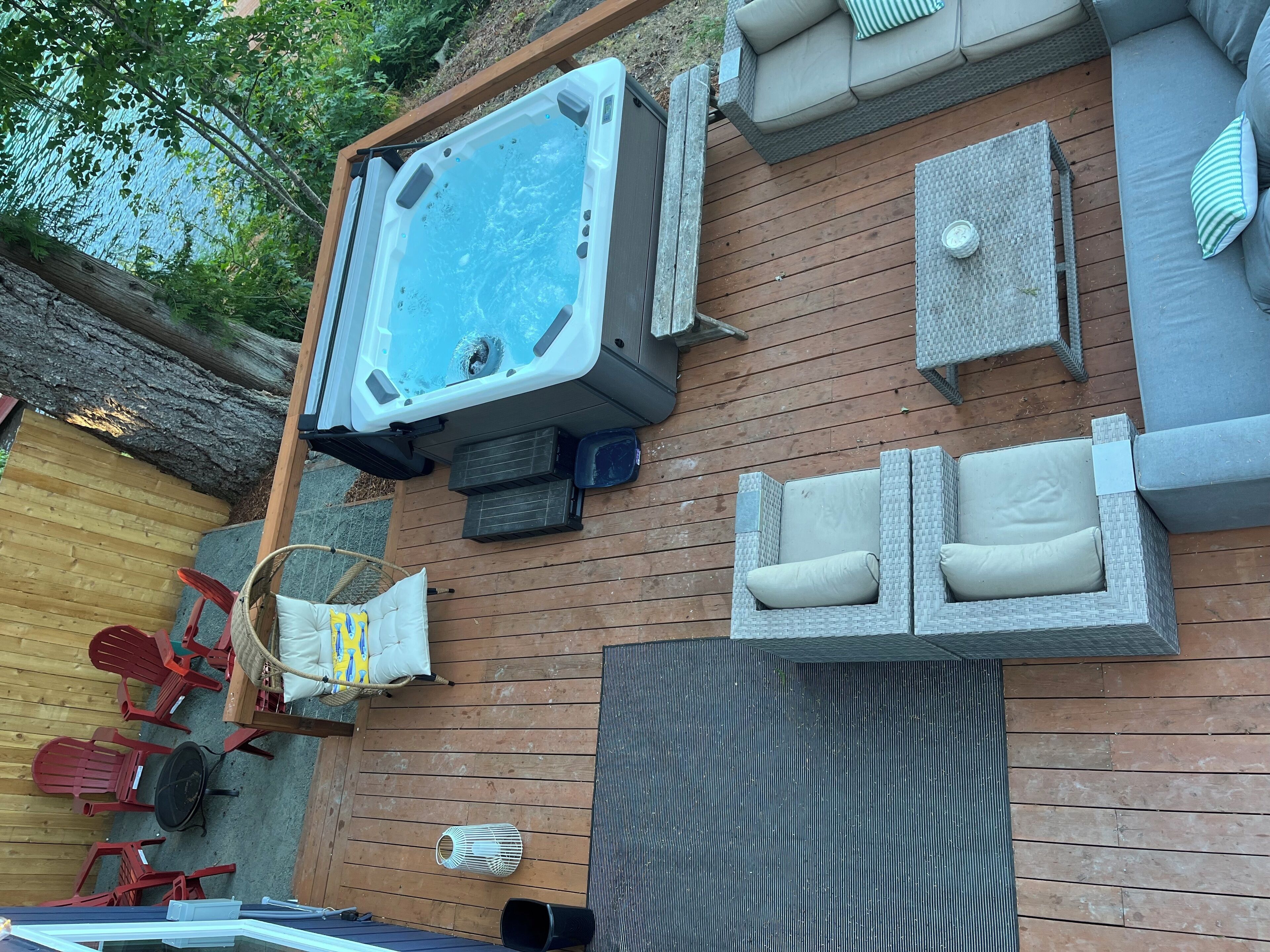 A hot tub, outdoor seating, and a wooden deck.