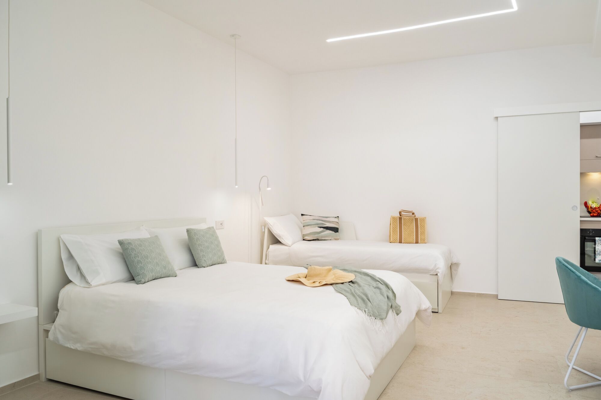 Une chambre à coucher au style minimaliste, avec deux lits, un bureau et une chaise.