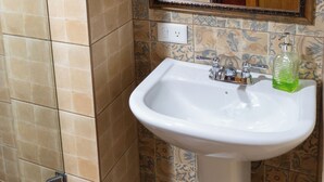Ein Badezimmer mit Dusche, Waschbecken und Spiegel.