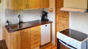 A compact kitchen with wooden cabinets, a stainless steel sink, a coffee maker, a dishwasher, and a stove. - 2 bedroom nice home in Hafjell (Hafjell)