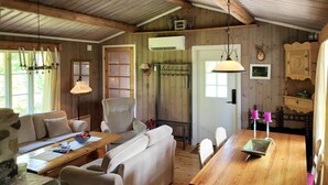 A cozy cabin interior with a wooden ceiling, a sofa, a dining table, and a chair. - 2 bedroom nice home in Hafjell (Hafjell)