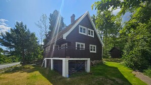 A two-story house with a dark exterior, white trim, and a visible garage. - Amazing home in Svelvik with WiFi (Svelvik)