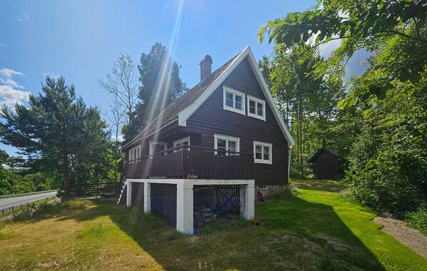 A two-story house with a dark exterior, white trim, and a visible garage.