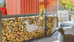 A glass wall with a stack of firewood and a chair outside. - Awesome home in Nørre Nebel with WiFi (Nørre Nebel)