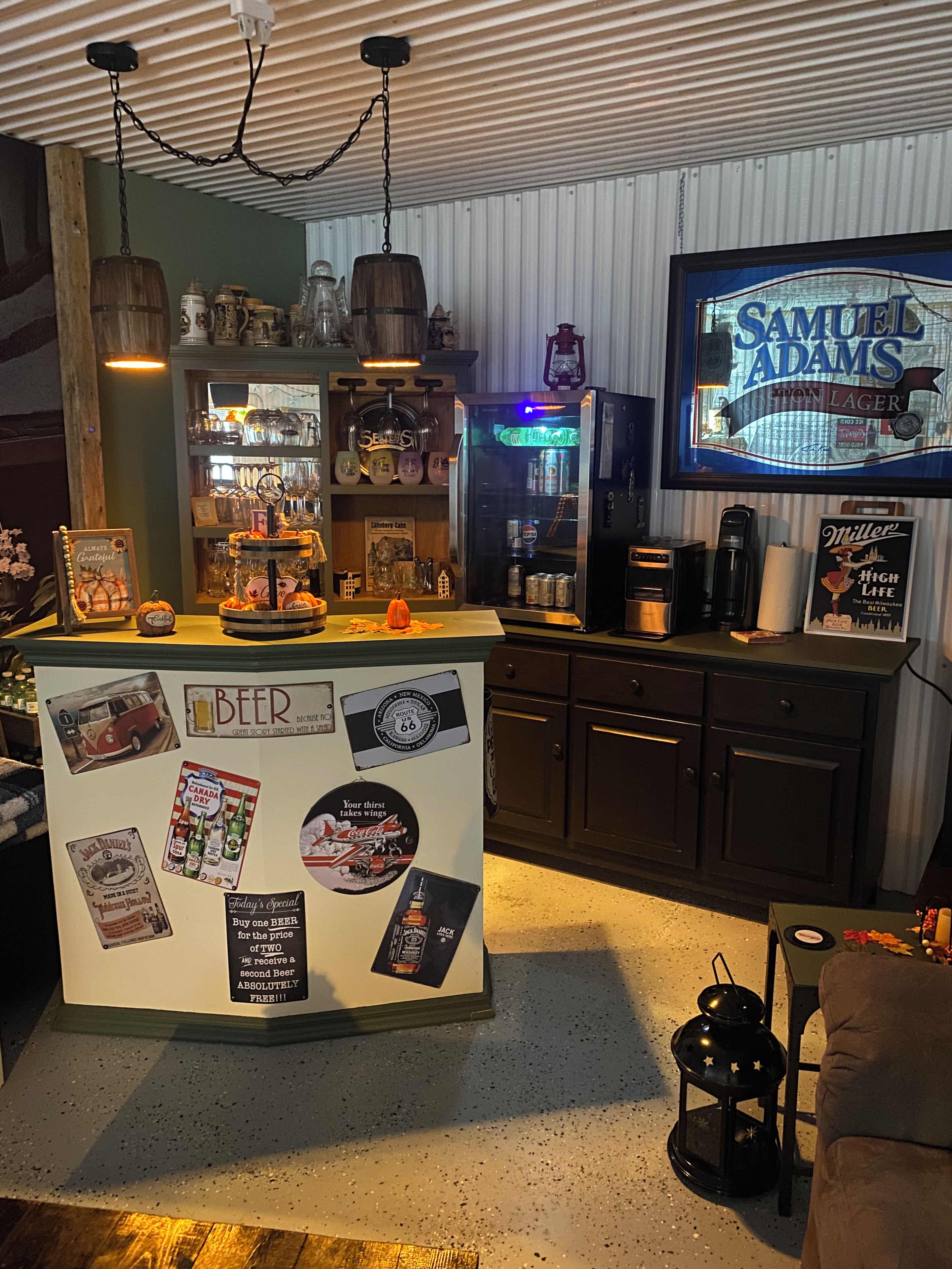 A bar area with a counter displaying various beer-related memorabilia and a television screen above it.