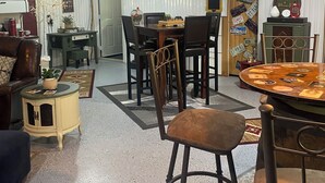 Un comedor acogedor y bien iluminado con una mesa y sillas de madera, rodeado de diversos objetos decorativos y recuerdos.