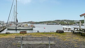 A marina with boats docked, a wooden bench, and a rocky shoreline. - 1 bedroom cozy home in Vrångö (Vrångö)