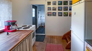 A compact kitchen with a stove, a coffee maker, and a refrigerator. - 1 bedroom cozy home in Vrångö (Vrångö)