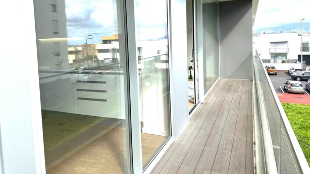 A modern building with large glass windows and a balcony. - Azores Paim Apartment T2 21A (Ponta Delgada)