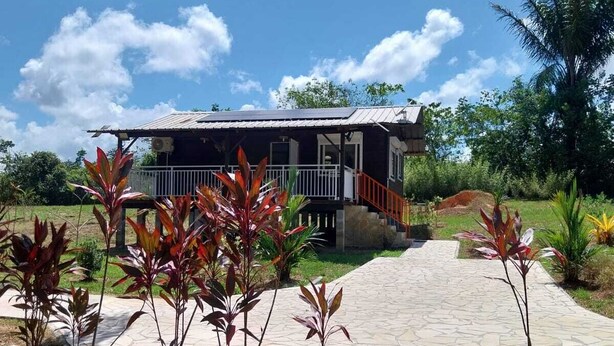 Ein Haus mit einer Veranda und einem gepflasterten Weg zum Eingang.
