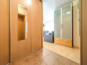 Une chambre moderne avec une armoire en bois, un canapé gris et un grand placard à portes coulissantes.