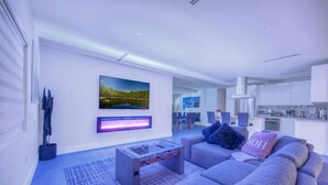 Ein modernes Wohnzimmer mit einer Couch, einem Couchtisch und einem an der Wand befestigten Flachbildfernseher.