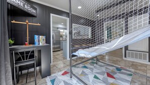 A room with a gaming area featuring a desk, chairs, a hammock, and a netted play area. - Military in Style/Movie Room /Game Room Minutes from Ft. Benning & Downtown area (Columbus)