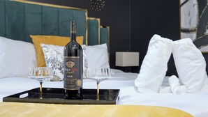 A hotel room with a bed, a bottle of wine, two wine glasses, and towels. - Military in Style/Movie Room /Game Room Minutes from Ft. Benning & Downtown area (Columbus)