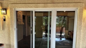 A sliding glass door leading to a covered patio area with a concrete floor and a potted plant on the left. - 3-bedroom apartment in charming Prescott Valley with WiFi, AC, and Heat (Prescott Valley)