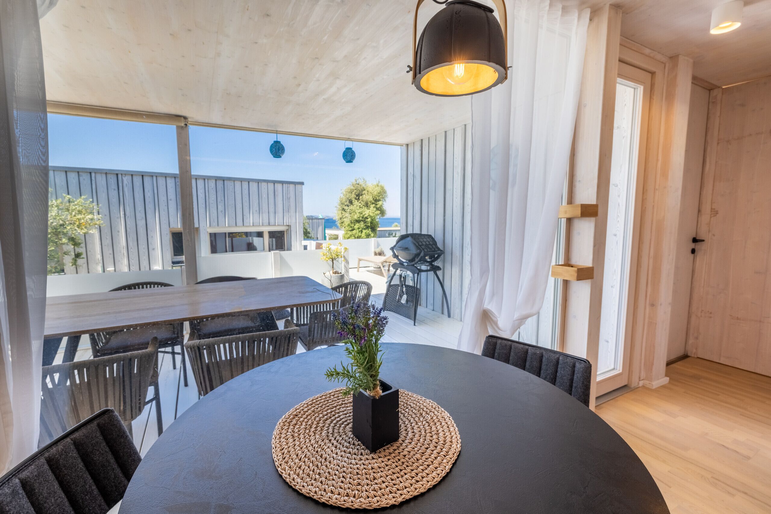Un coin repas avec une table ronde, des chaises et une plante en pot.