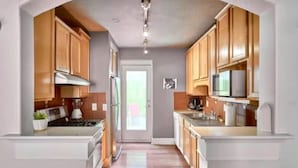 A modern kitchen with wooden cabinets, a stainless steel range, and a built-in microwave. - Terrific Dallas Location! 2BR w/ Wi-Fi & A/C – Knight 205 (Dallas)
