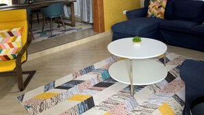 A living room with a sofa, a coffee table, and a patterned rug. - THEMI RIVER RETREAT- Secure 3BR Near Arusha Bypass  (Arusha)