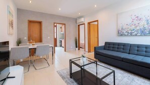 Un salon moderne avec un canapé, une table basse et un coin repas.