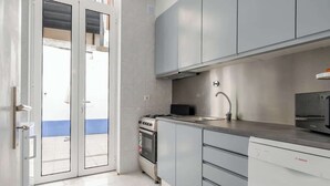 Una cocina moderna con electrodomésticos de acero inoxidable, gabinetes grises y lavavajillas.
