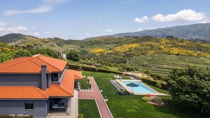 A modern house with a red-tiled roof, a swimming pool, and a well-maintained lawn. - 10BR Douro Villa with Pool by HostWise (Santa Marinha do Zêzere)