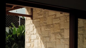 Una cocina con pared de piedra, ventana y lavabo.