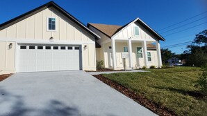 A two-story house with a garage, a front lawn, and a mailbox. - 3-bedroom house in Orlando near Universal Studios (Orlando)