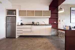A modern kitchen with a built-in refrigerator, microwave, and coffee maker.