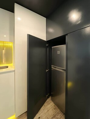 Una cocina moderna con un refrigerador integrado, un microondas y una encimera de madera.