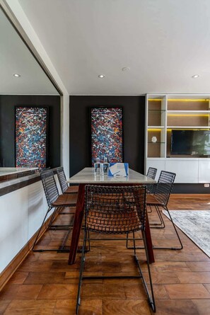 Un comedor moderno con una mesa, sillas y arte abstracto en las paredes.