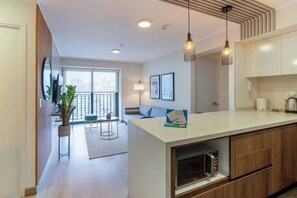 Eine moderne Wohnung mit Kücheninsel, Essbereich und Balkon mit Blick.