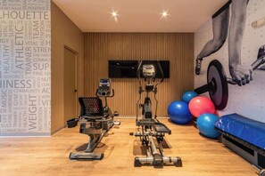 A gym with cardio machines, a TV, and exercise balls. - Geko | Central 2BR Flat in Barranco w/Balcony (Lima)