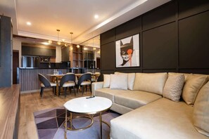 Un salon moderne avec un canapé, une table basse ronde et un coin repas comprenant des chaises et une table.