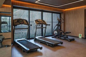 A modern gym with treadmills, stationary bikes, and exercise equipment.