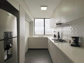 Una cocina moderna con estufa integrada, cafetera y dispensador de agua.