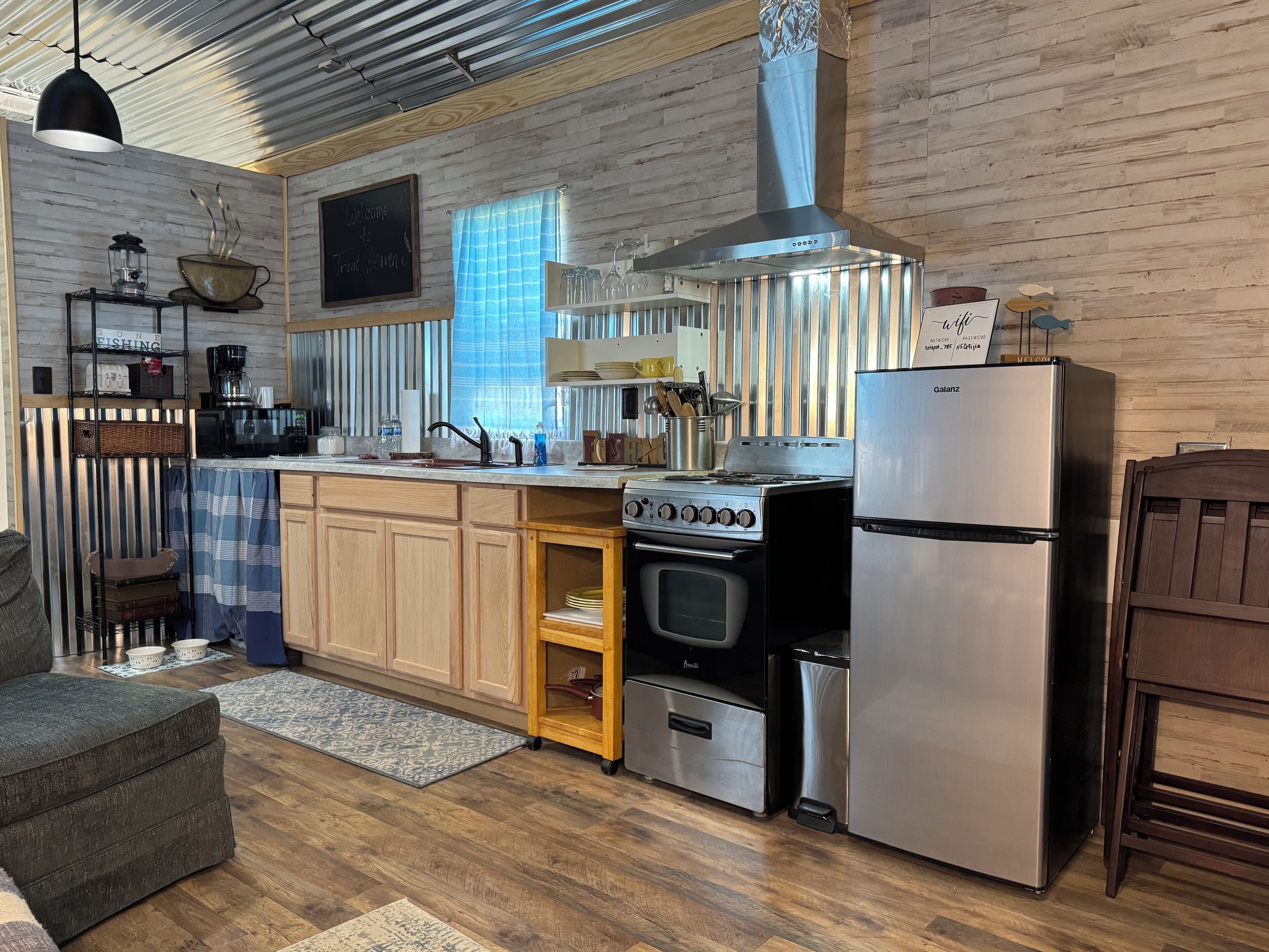 A modern kitchen with wooden cabinets, a stainless steel stove, and a refrigerator.