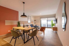 Un espacio habitable moderno con comedor, sofá y ventanas amplias.
