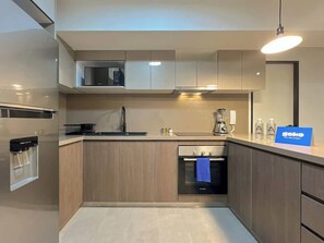 Una cocina moderna con electrodomésticos integrados, microondas y lavabo.